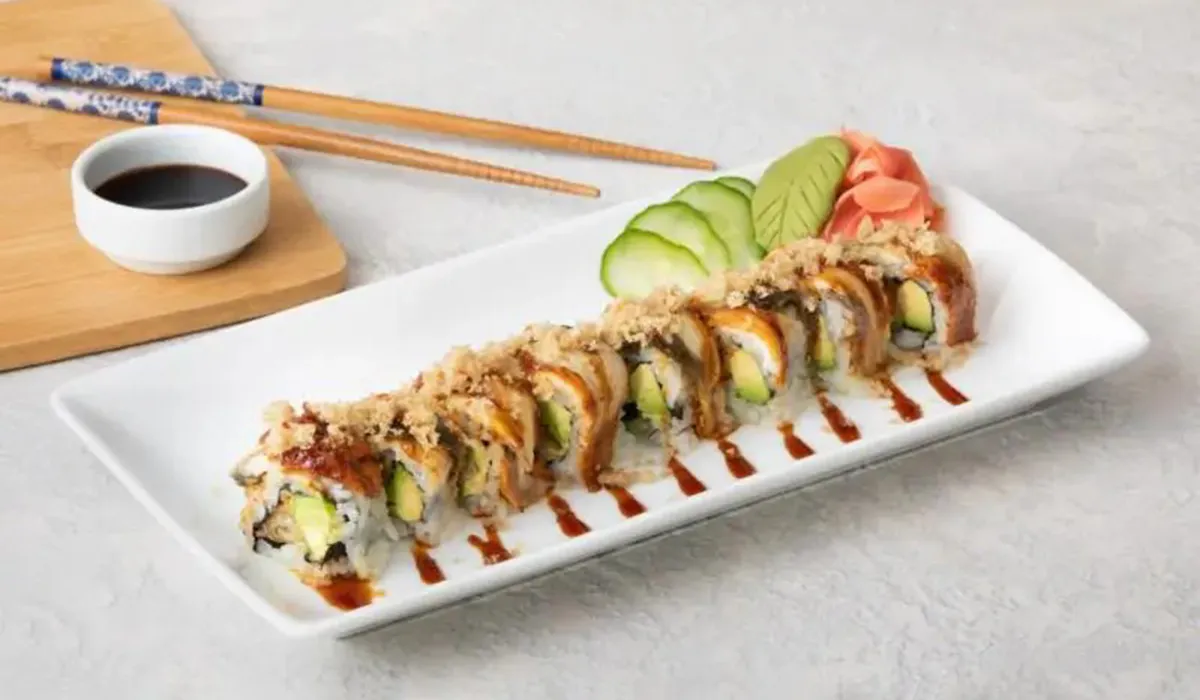 Sushi roll with avocado and shrimp topping served on a white plate